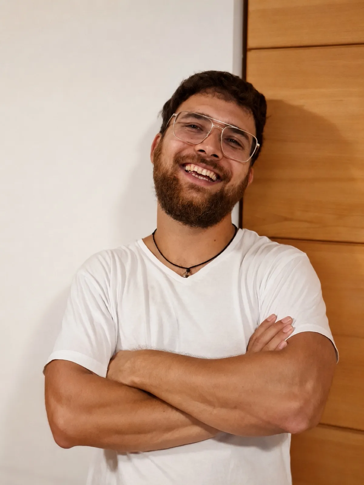 Matthias Salzer, Heilmasseur, mit verschränkten Armen an eine helle Wand gelehnt